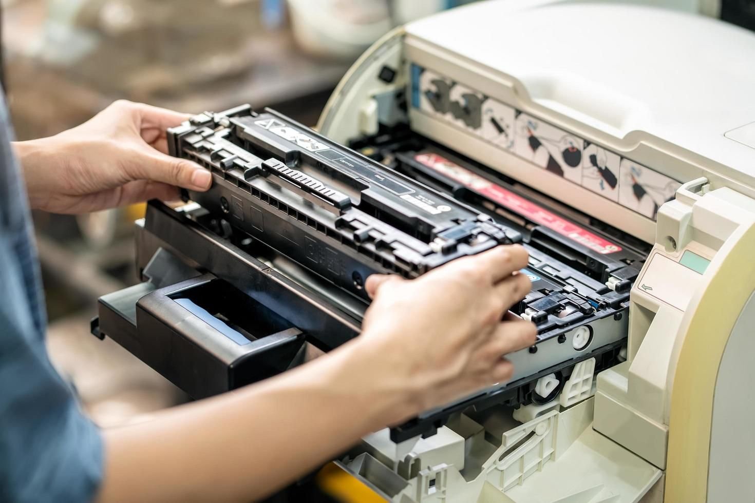 Technician replacing a toner cartridge during printer maintenance